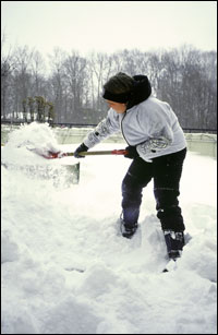 Shoveling snow from a driveway.