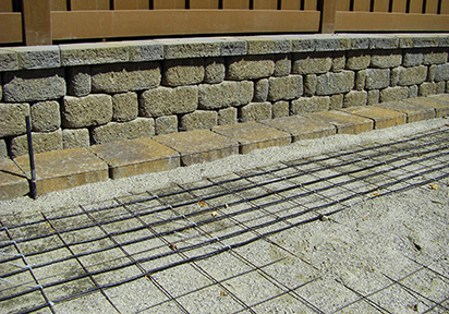 Installing heated stone paver tire tracks in driveway.