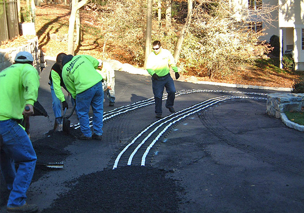 BEFORE - An asphalt driveway with heated tire tracks being installed.
